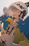 1boy arumikan_zzz black_hair chest_tattoo coat coat_on_shoulders collarbone commentary earrings facial_hair finger_tattoo fur_coat hand_tattoo hat highres jewelry looking_at_viewer male_focus one_piece parted_lips serious shirt short_hair solo sword tattoo trafalgar_law untranslatable_commentary upper_body weapon white_hat yellow_eyes yellow_shirt 