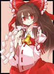  ascot bare_shoulders blush border brown_hair collarbone detached_sleeves gohei hair_tubes hakurei_reimu highres holding kikiriri long_hair looking_at_viewer red_eyes solo touhou 