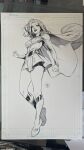  1girl belt black_lips black_shorts boots cape clenched_hands dan_mora dc_comics floating_cape greyscale grin highres legs long_hair long_sleeves looking_at_viewer marker_(medium) miniskirt monochrome photo_(medium) shorts signature skirt smile solo supergirl superhero_costume superman_(series) thighs toned toned_female traditional_media 