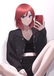 1girl absurdres black_jacket black_shirt black_shorts cellphone closed_mouth collarbone commentary_request hair_between_eyes highres holding holding_phone jacket long_sleeves looking_at_viewer love_live! love_live!_school_idol_project medium_hair nishikino_maki open_clothes open_jacket phone purple_eyes red_hair s_sho_mkrn shirt shorts sitting smartphone solo upper_body white_background 