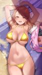  1girl armpits arms_up beach_towel bikini blush breasts brown_eyes brown_hair cleavage collarbone condom_box gold_bikini highres hojo_karen idolmaster idolmaster_cinderella_girls large_breasts long_hair looking_at_viewer lying mk_(mod0) navel on_back open_mouth sand side-tie_bikini_bottom smile solo swimsuit towel 