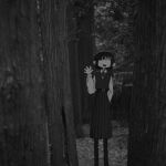  1girl absurdres commentary_request feet_out_of_frame greyscale hand_up highres long_sleeves monochrome narue open_mouth original outdoors pantyhose photo_background pleated_skirt short_hair skirt smile solo standing tree vest waving 