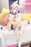  1girl absurdres ahoge animal_ears barefoot bed check_commentary chinese_commentary commentary_request controller curtains fox_girl_(fenri) green_skirt head-mounted_display highres indoors jacket kneehighs long_hair long_sleeves looking_at_viewer night on_bed original pillow pink_hair puffy_sleeves school_uniform skirt socks solo star-shaped_pillow teketi thighhighs window yellow_jacket 