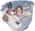 1girl absurdres animal_pillow bed bedroom black_legwear bookshelf brown_hair cellphone clock commentary futon green_eyes grin highres indoors looking_at_viewer lying medium_hair night on_bed on_stomach orange_tank_top original phone pillow plant smile socks solo tank_top w4pz window 