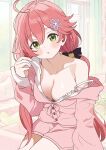  1girl :o absurdres ahoge alternate_costume bell black_bow blurry blurry_background bow breasts cleavage double-parted_bangs green_eyes hair_bell hair_between_eyes hair_bow hair_ornament hand_up highres hololive hutaba_haru indoors long_hair long_sleeves looking_at_viewer loungewear low_twintails medium_breasts official_alternate_hairstyle open_mouth pink_hair pink_shirt pink_shorts sakura_miko shirt short_shorts shorts single_bare_shoulder single_off_shoulder sitting solo strap_slip twintails virtual_youtuber 