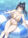  1girl bikini black_hair blue_eyes blush breasts cleavage closed_mouth commentary english_commentary gold_bikini hair_intakes highres hololive hololive_english innertube large_breasts long_hair looking_at_viewer navel nurizza_ilst on_innertube ouro_kronii ponytail sitting solo stomach string_bikini swim_ring swimsuit virtual_youtuber water 