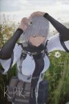  1girl absurdres ammunition_pouch black_bodysuit bodysuit breasts chamomile character_name closed_eyes commentary diao_guo_yu english_commentary english_text field flower flower_field girls'_frontline grey_hair hair_flower hair_ornament highres jacket medium_breasts medium_hair multicolored_jacket open_mouth photo_background pouch rpk-16_(girls'_frontline) smile solo standing teeth twitter_username two-tone_jacket upper_body white_jacket wide_sleeves 