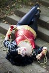  1girl amazon black_hair blue_eyes bracer bracers cosplay dc_comics jacket lasso lying on_back pants photo solo tiara wonder_woman wonder_woman_(series) 