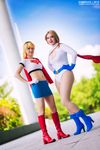  2girls blonde_hair boots cape cosplay dc_comics gloves hands_on_hips jenni_hashimoto leotard multiple_girls photo power_girl s_shield smile supergirl superman_(series) 