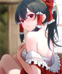  1girl back bare_shoulders black_hair bow breast_hold breasts chest_sarashi commentary_request embarrassed frills from_behind hair_bow hair_tubes hakurei_reimu highres indoors kisaragi_koushi looking_at_viewer looking_back medium_breasts partially_undressed ponytail red_bow red_eyes red_shirt sarashi shirt sitting solo touhou undressing 