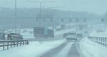  absurdres box_truck car day divided_highway highres highway lamppost motor_vehicle no_humans outdoors power_lines road road_sign sign simon_stalenhag sky snow sports_utility_vehicle swedish_machines traffic tree truck van winter 