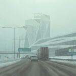  architecture box_truck building car day divided_highway highres highway lamppost motor_vehicle no_humans outdoors road road_sign science_fiction semi_truck sign simon_stalenhag sky sports_utility_vehicle swedish_machines swedish_text traffic trailer truck van 