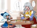  2girls blue_dress blue_hair blurry blurry_background blush bow breasts chewing chopsticks cirno commentary cushion dress food fuuga_(perv_rsity) hair_bow holding holding_food ice ice_wings multicolored_dress multiple_girls open_mouth red_eyes round_table sakata_nemuno short_sleeves sitting strapless strapless_dress sunglasses table tanned_cirno touhou translated wings wooden_table 