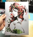  1girl art_tools_in_frame artist's_hand_in_frame bare_shoulders batman_(series) breasts cleavage closed_mouth commentary cropped_torso dc_comics english_commentary green_eyes highres leaf_clothing long_hair marker_(medium) photo_(medium) plant_clothing poison_ivy red_hair red_nails signature solo stanley_lau traditional_media turning_head white_background 