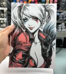  1girl art_tools_in_frame artist's_hand_in_frame batman_(series) blonde_hair blue_eyes blue_hair breasts cleavage closed_mouth commentary dc_comics ear_piercing earrings english_commentary harley_quinn highres jacket jewelry looking_at_viewer marker_(medium) multicolored_jacket photo_(medium) piercing red_hair red_jacket red_lips signature smile solo stanley_lau traditional_media twintails upper_body white_background 