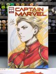  1girl art_tools_in_frame blonde_hair blue_eyes captain_marvel_(carol_danvers) closed_mouth commentary cover_sketch english_commentary hair_slicked_back marker_(medium) marvel outline photo_(medium) red_shirt shirt short_hair signature solo stanley_lau traditional_media upper_body yellow_outline 
