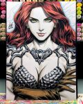  1girl armor art_tools_in_frame bikini_armor breasts brown_gloves cleavage closed_mouth commentary crossed_arms earrings english_commentary gloves green_eyes highres jewelry long_hair looking_at_viewer marker_(medium) pauldrons photo_(medium) red_hair red_sonja red_sonja_(comics) scale_armor shoulder_armor signature solo stanley_lau straight-on traditional_media 
