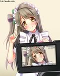  blurry blush brown_hair depth_of_field head_tilt highres long_hair looking_at_viewer love_live! love_live!_school_idol_project maid maid_headdress minami_kotori pointing pointing_up smile solo song_name viewfinder wonder_zone yellow_eyes yu-ta 