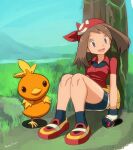  1girl against_tree bag bandana bike_shorts bike_shorts_under_skirt blue_eyes brown_hair collared_shirt commentary_request day eyelashes fanny_pack gloves grass holding holding_poke_ball looking_to_the_side may_(pokemon) medium_hair outdoors poke_ball poke_ball_(basic) pokemon pokemon_(creature) pokemon_ruby/sapphire/emerald red_bandana red_shirt ryuntack shirt shoes short_sleeves signature skirt socks torchic tree white_skirt yellow_bag 