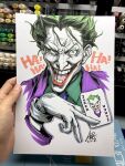  1boy art_tools_in_frame artist's_hand_in_frame batman_(series) card commentary cropped_torso dc_comics english_commentary gloves green_eyes green_hair green_shirt highres joker_(dc) joker_(playing_card) laughing looking_at_viewer male_focus marker_(medium) photo_(medium) playing_card purple_suit shirt short_hair signature solo stanley_lau suit teeth traditional_media white_background white_gloves 