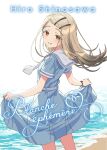  1girl blonde_hair blue_dress blush character_name commentary_request dress french_text from_behind gakuen_idolmaster hair_ornament hairclip highres holding_own_dress idolmaster kousuke0912 long_hair looking_at_viewer looking_back orange_eyes parallel_hairclips sailor_collar sailor_dress shinosawa_hiro short_sleeves smile solo water white_sailor_collar 