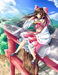 :o blue_sky blush bow brown_hair cloud day detached_sleeves frilled_skirt frills hair_bow hair_tubes hakurei_reimu hand_in_hair highres leg_lift lens_flare long_hair looking_to_the_side mary_janes midriff mountain navel outdoors red_eyes shoes sitting_on_torii skirt skirt_set sky solo torii touhou unory wind 