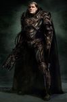  alien armor brown_eyes cape crest dc_comics dccu dru-zod family_crest full_armor full_body gauntlets gradient gradient_background gun knife kryptonian looking_at_viewer male_focus man_of_steel realistic short_hair solo standing superman_(series) weapon 