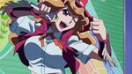  1girl announcer belt breasts cowboy_hat female fringe hat holding_microphone large_breasts light_brown_hair melissa_claire microphone screencap shirt smile vest wink yu-gi-oh! yuu-gi-ou_arc-v 