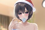  1girl black_hair blurry blurry_background blush collarbone commentary_request condom condom_in_mouth condom_wrapper hat highres kiona_(giraffe_kiona) looking_at_viewer mouth_hold original purple_eyes red_headwear santa_hat short_hair solo 