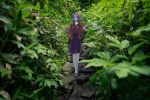  1girl absurdres blurry commentary_request depth_of_field forest full_body geta hair_ribbon highres holding holding_smoking_pipe japanese_clothes kimono kiseru komakusa_sannyo leftame long_hair long_sleeves looking_at_viewer nature outdoors photo_background ponytail purple_hair purple_skirt red_eyes red_kimono red_robe ribbon robe skirt smoke smoking_pipe solo touhou yellow_ribbon 