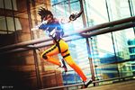  ardsami belt bodysuit brown_hair city cosplay goggles gun leggings legs overwatch running shoes short_hair skyscraper spandex tracer_(overwatch) weapon window 