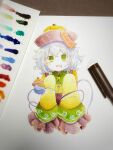  1girl adapted_costume alternate_headwear art_tools_in_frame blush collared_shirt commentary_request eyeball floral_print frilled_shirt_collar frilled_sleeves frills green_eyes grey_hair hat headwear_request highres jiangshi komeiji_koishi long_sleeves looking_at_viewer ofuda open_mouth outstretched_arms photo_(medium) print_sleeves rose_print shiro_tsugumi shirt sleeves_past_fingers sleeves_past_wrists solo third_eye touhou wide_sleeves yellow_shirt zombie_pose 