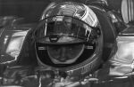  1boy car commentary english_commentary fabiodesenhando formula_one graphite_(medium) greyscale helmet highres looking_at_viewer male_focus michael_schumacher monochrome motor_vehicle motorcycle_helmet photorealistic real_life realistic reflection signature solo straight-on traditional_media vehicle_interior 