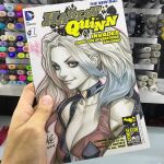  1girl art_tools_in_frame artist's_hand_in_frame batman_(series) black_choker blonde_hair blue_eyes blue_hair breasts choker cleavage closed_mouth commentary cover_sketch curtained_hair dc_comics english_commentary gradient_hair harley_quinn heart heart_choker jacket looking_at_viewer marker_(medium) multicolored_hair photo_(medium) signature smile solo stanley_lau traditional_media upper_body 