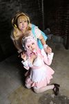 2girls asian blonde_hair breasts brown_eyes cleavage cosplay fat headphones hoshima_mika huge_breasts jewelry multiple_girls necklace nitroplus photo pink_hair star super_pochaco super_pochaco_(cosplay) super_sonico super_sonico_(cosplay) twintails 
