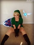  1girl blonde_hair boots chelhellbunny cosplay gloves hood linkle looking_at_viewer nail_polish photo shield sitting smile solo the_legend_of_zelda 