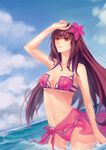  adapted_costume bare_shoulders bikini blue_sky breasts brown_hair cleavage cloud cloudy_sky collarbone cowboy_shot day fate/grand_order fate_(series) flower hair_flower hair_ornament hand_to_head hand_up hibiscus highres large_breasts long_hair looking_away mao_mao_wansui midriff navel ocean open_mouth outdoors purple_bikini purple_sarong red_eyes sarong scathach_(fate)_(all) scathach_(swimsuit_assassin)_(fate) sidelocks sky smile solo stomach swimsuit underboob wading water 