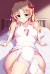  1girl arm_support bangs bare_shoulders bed bed_sheet blonde_hair blush breasts closed_mouth commentary_request elbow_pads eyebrows_visible_through_hair green_eyes gym_shorts gym_uniform hair_ornament hair_ribbon headband huyumitsu indoors knee_pads knee_up long_hair looking_at_viewer medium_breasts number on_bed original pillow pink_shorts red_ribbon ribbon shirt shorts sitting sleeveless sleeveless_shirt smile solo sportswear uniform volleyball_uniform white_shirt 