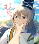  1girl 1other absurdres black_hat blue_eyes blue_sky blurry blurry_background closed_mouth cloud commentary_request grey_hair hair_between_eyes hat highres japanese_clothes kariginu long_sleeves looking_at_viewer medium_hair meme mononobe_no_futo moriya210 nejime outdoors ponytail pov pov_cheek_grabbing_(meme) ribbon-trimmed_sleeves ribbon_trim sky solo tate_eboshi touhou upper_body wide_sleeves 