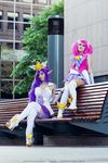  2girls boots cosplay elf english feli_dragoon high_heel_boots high_heels janna_windforce league_of_legends long_hair looking_at_viewer luxanna_crownguard multiple_girls outdoor pink_hair purple_hair sitting skirt star twintails valentina_kryp wig 