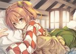 apron bell blush brown_eyes brown_hair checkered checkered_shirt closed_mouth commentary_request fal_maro forbidden_scrollery green_skirt hair_bell hair_ornament jingle_bell long_sleeves looking_at_viewer lying motoori_kosuzu on_stomach pillow pillow_hug shirt short_hair skirt smile solo touhou two_side_up wide_sleeves 