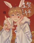  1boy ahoge amo_(amo_0514) animal_ears body_writing brown_eyes brown_hair chinese_new_year chinese_zodiac circle closed_mouth commentary double-parted_bangs earrings english_commentary extra_ears facepaint fur-trimmed_jacket fur_trim gem gold_ring green_gemstone hair_between_eyes hair_ornament hairclip hand_on_own_chin hands_up happy_new_year head_rest highres hoop_earrings jacket jewelry kemonomimi_mode light_smile long_sleeves looking_at_viewer male_focus necklace open_clothes open_jacket original pointing pointing_at_viewer print_sweater rabbit_ears red_background red_sweater ribbed_sweater ring short_hair single_earring solo sweater translation_request upper_body white_jacket year_of_the_rabbit 
