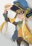  1girl agent_3_(splatoon) blonde_hair blue_hat closed_mouth cowboy_shot frown hand_on_headwear hat headgear highres inkling inkling_girl inkling_player_character koike3582 long_hair long_sleeves orange_eyes patchwork_clothes peaked_cap poncho solo splatoon_(series) splatoon_3 suction_cups tentacle_hair torn_clothes very_long_hair 