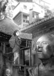  architecture bad_id bad_pixiv_id blurry buddhism depth_of_field east_asian_architecture greyscale hands_on_own_chest hat house japanese_clothes katou_fumitaka light long_hair looking_to_the_side monk_kuuya monochrome open_mouth original scenery solo staff statue straw_hat 