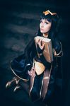  1girl black_hair blunt_bangs bodystocking bodysuit book cape circlet cosplay fire_emblem fire_emblem:_kakusei hair_ornament holding_book looking_at_viewer photo sitting solo tharja tharja_(cosplay) twintails 