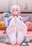 1girl absurdres andy2465 bed_sheet camera collarbone convenient_leg feet foot_focus foreshortening full_body gradient_eyes hair_between_eyes hair_intakes hand_up highres holding holding_camera honkai:_star_rail honkai_(series) indoors knees_up legs_together long_sleeves looking_at_viewer march_7th_(honkai:_star_rail) medium_hair multicolored_eyes nail_polish no_shoes on_bed open_mouth pantyhose photo_(object) pillow pink_hair purple_eyes see-through see-through_legwear sitting soles solo teeth toenails toes upper_teeth_only white_pantyhose 