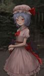  1girl absurdres black_wings blurry blurry_background dholewolf dress fangs feet_out_of_frame hat highres looking_at_viewer medium_hair mob_cap pink_dress pink_hat purple_hair red_eyes red_ribbon remilia_scarlet ribbon short_sleeves solo touhou wings 