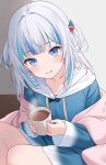 1girl animal_costume blanket blue_eyes blue_hair blue_sweater blush cup gawr_gura gawr_gura_(1st_costume) hair_ornament highres hitsukuya hololive hololive_english hood hooded_sweater licking_lips long_sleeves looking_at_viewer medium_hair multicolored_hair shark_costume shark_girl shark_hair_ornament smile solo streaked_hair sweater tongue tongue_out two_side_up virtual_youtuber white_hair 