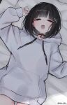  1girl :o absurdres black_choker black_hair blunt_bangs blush choker commentary_request dot_nose ear_piercing fingernails from_above hair_ornament head_on_pillow highres hood hoodie letter_hair_ornament long_fingernails long_sleeves looking_at_viewer medium_hair nibo_shia on_bed open_mouth original piercing pillow puffy_long_sleeves puffy_sleeves sleeves_past_wrists solo white_hoodie 