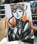  1girl 2017 animal_ears art_tools_in_frame artist's_hand_in_frame batman_(series) breasts catsuit catwoman commentary dc_comics english_commentary fake_animal_ears goggles goggles_on_head highres holding holding_whip looking_at_viewer marker_(medium) parted_lips photo_(medium) signature solo stanley_lau traditional_media upper_body whip 